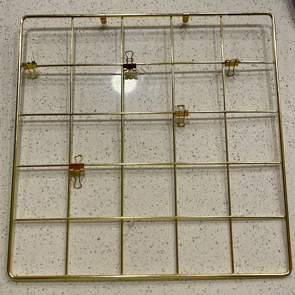 All gold vision board with clips and place to screw in the wall.